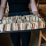 50 Medium Catering Platters & 50 Lids & 50 Allergy Labels presented with a variety of sandwiches in a clear container.